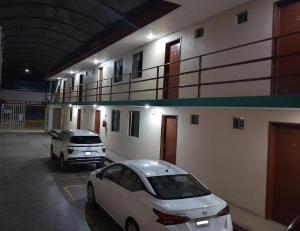 two cars parked in a parking lot next to a building at Bugambilia Campeche in Campeche