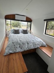 1 cama en una casa pequeña con ventana en Luxury Beach Bus, en Whanganui
