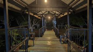 a wooden walkway at night with lights on at FZ Tuaran Country Village in Tuaran +3 photos