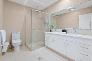a bathroom with a shower and a toilet and a sink at Abby's Burleigh Haven Unit 2 in Gold Coast +17 photos