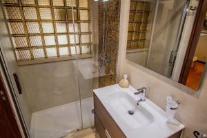 a bathroom with a sink and a shower at Casas das Pedrinhas by Paisagens Inéditas in Travanca