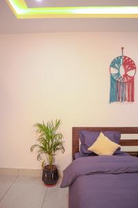 a bedroom with a bed and a potted plant at Blissful stays midst nature in Rishīkesh