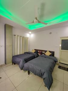 two beds in a room with a ceiling with green lights at Blissful stays midst nature in Rishīkesh