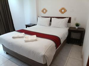 una camera da letto con un letto grande con due asciugamani sopra di PAKARINA HOTEL a Machu Picchu Altre 27 foto