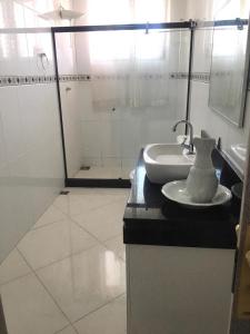 a white bathroom with a sink and a mirror at Suíte FAMILIAR Varandão Aeroporto Internacional in Rio de Janeiro +28 photos
