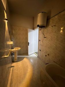 a bathroom with a bath tub and a sink at Downtown Lucky Apartment in Cairo