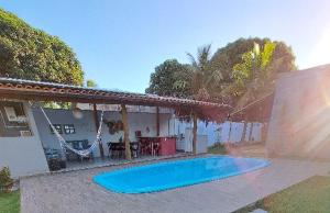 a swimming pool in front of a house at Bangalôs Vila do Arraial in Arraial d'Ajuda