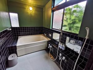 a bathroom with a bath tub and a sink at Mt Fuji Historical Oshi house hitsuki in Fujiyoshida +38 photos