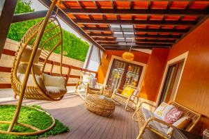 a porch with wicker chairs and a porch swing at Casas das Pedrinhas by Paisagens Inéditas in Travanca