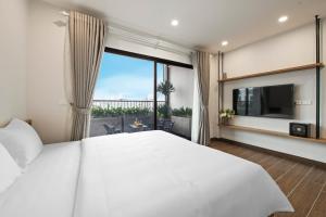 een slaapkamer met een groot wit bed en een groot raam bij The Literature'N Central Hotel and Travel Ha Noi 177 in Hanoi