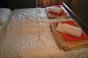 a bed with white sheets and towels on it at Apartment Relax in Zrenjanin