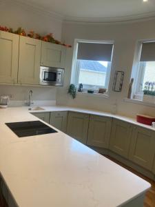 a kitchen with a white counter top and two windows at The Bunker, Golf Cottage in Prestwick +24 photos