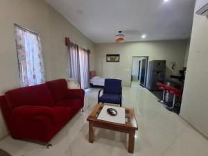 ein Wohnzimmer mit einem roten Sofa und einem Tisch in der Unterkunft Departamentos La Roca D7 in La Peñita de Jaltemba