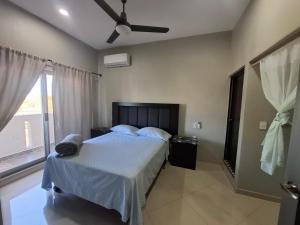 ein Schlafzimmer mit einem Bett mit Deckenventilator in der Unterkunft Departamentos La Roca D7 in La Peñita de Jaltemba