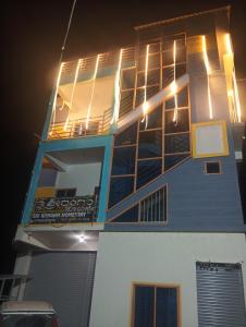 a building with lights on top of it at night at Rooms & Food Sri Ranga in Belūr