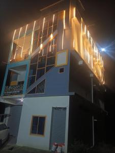 a building with lights on top of it at night at Rooms & Food Sri Ranga in Belūr