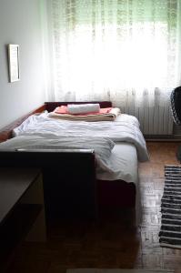 a bed in a bedroom with a large window at Apartment Relax in Zrenjanin