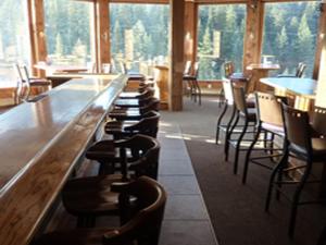 a row of chairs sitting at a bar in a restaurant at Soda Butte Lodge in Cooke City