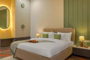 a bedroom with a large white bed with green walls at SaffronStays Mont Tierra - 4BR modern villa with lawn, bonfire, indoor games & themed rooms, Dehradun in Dehradun +35 photos