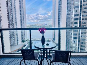 a table with chairs and a vase with flowers on a balcony at R&F Seine Region in Johor Bahru