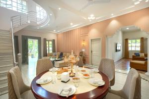 a dining room with a table and chairs at SaffronStays Mont Tierra - 4BR modern villa with lawn, bonfire, indoor games & themed rooms, Dehradun in Dehradun