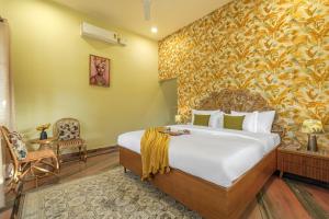 a bedroom with a bed and a yellow wall at SaffronStays Mont Tierra in Dehradun