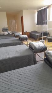 a group of beds in a room with a room with at Dormitorio de La Estancia del Abuelo in San José Iturbide