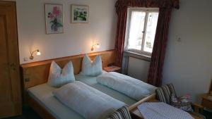 a bedroom with two beds with pillows and a window at Villa Bergkristall in Eschenlohe