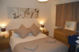 a bedroom with a bed with two pillows on it at Chesterton Court Apartment in Gloucester