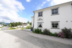 a white building with a sign on the side of it at Sandli Overnatting in Alvdal