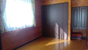 a room with a black door and a window at 貸別荘Lealeaプライベートコテージ in Fujikawaguchiko