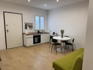 Una sala de estar con una mesa y una cocina. en Ai Marinai Maestrale Apartment, en Taranto