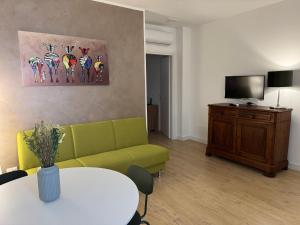Una sala de estar con un sofá verde y una mesa. en Ai Marinai Maestrale Apartment, en Taranto