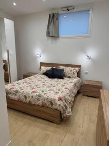 Un dormitorio con una cama con edredón y una ventana. en Ai Marinai Maestrale Apartment, en Taranto