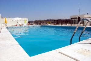 a large swimming pool with blue water at Tubarinho Apartment in Costa da Caparica