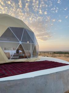 a tent on the roof of a building at Aman dome desert in Ḩawīyah