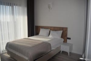 a bed in a bedroom with a large window at SG RESORT Apart Otel in Silifke +23 photos