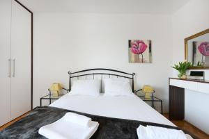 a bedroom with a white bed with two white pillows at Rooms and Apartments Diana in Zadar