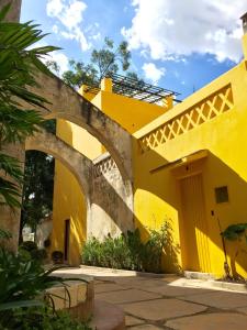 a yellow building with an archway in a yard at Bungalows Demetria in Guadalajara