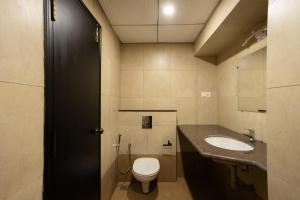 a bathroom with a toilet and a sink at Premier Greens, in Mūlki