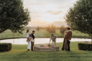 a group of people standing around a fire pit at Linnaeus Farm, Berry - by Linnaeus Collection in Berry