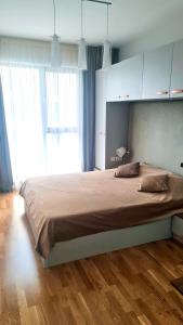 a bedroom with a large bed with a wooden floor at Escape The Ordinary in Bucharest
