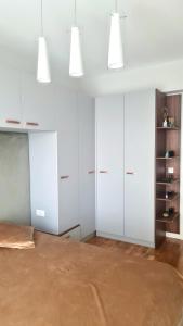 a bedroom with white cabinets and a brown floor at Escape The Ordinary in Bucharest
