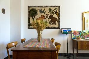 a dining room table with a vase of flowers on it at Le Monachette in Ascoli Piceno