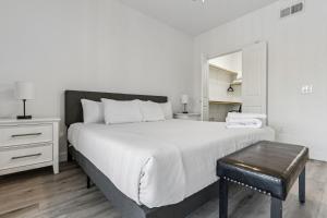 1 dormitorio con cama blanca grande y taburete en CozySuites Glendale by the stadium with pool 22, en Glendale 32 fotos más