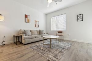 una sala de estar con un sofá y una mesa en CozySuites Glendale by the stadium with pool 22, en Glendale