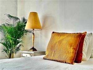a bed with a pillow and a lamp on a table at Casal Santa Virginia in Sintra