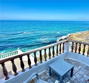 a blue bench sitting on a balcony overlooking the ocean at Casal Santa Virginia in Sintra