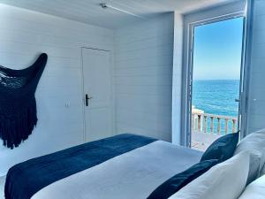 a bedroom with a bed and a view of the ocean at Casal Santa Virginia in Sintra