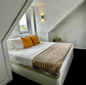 a bed with orange pillows in a small room at Casal Santa Virginia in Sintra